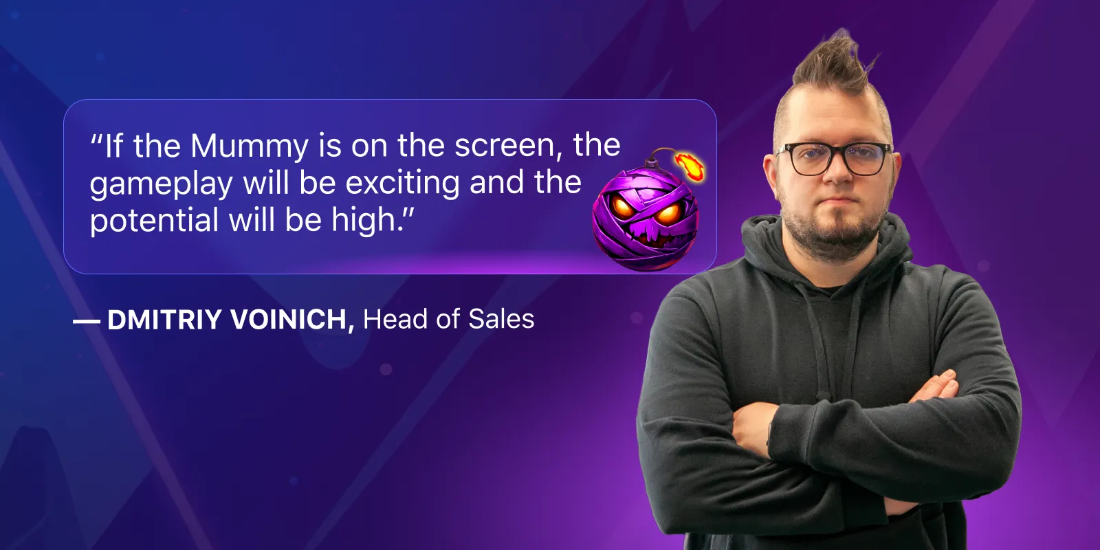 Dmitriy Voinich, diretor de vendas da Belatra Games, sorrindo ao lado dos principais elementos visuais da linha Mummyverse